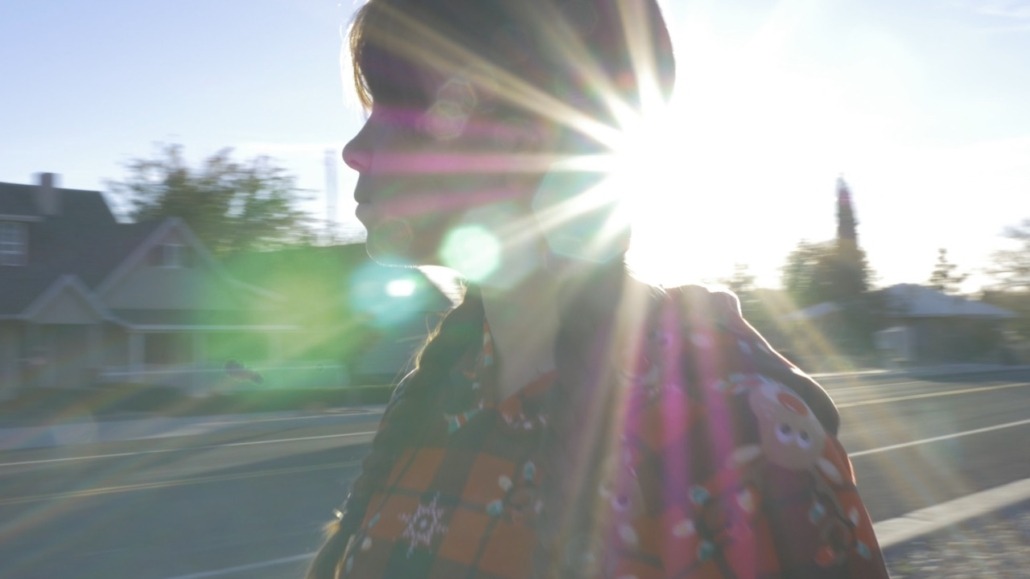 daughter walking with sun flare behind