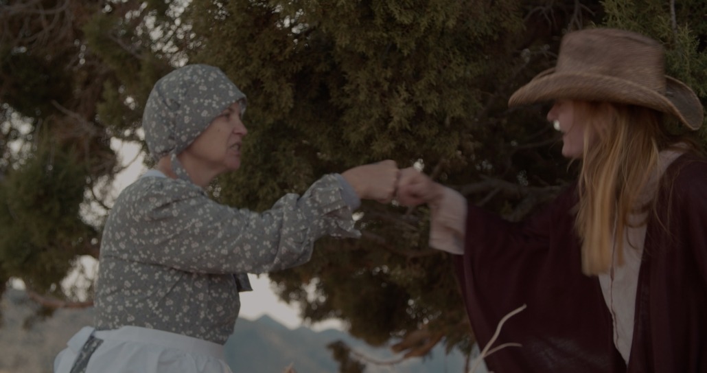 emma and lily fist bump in front of a tree