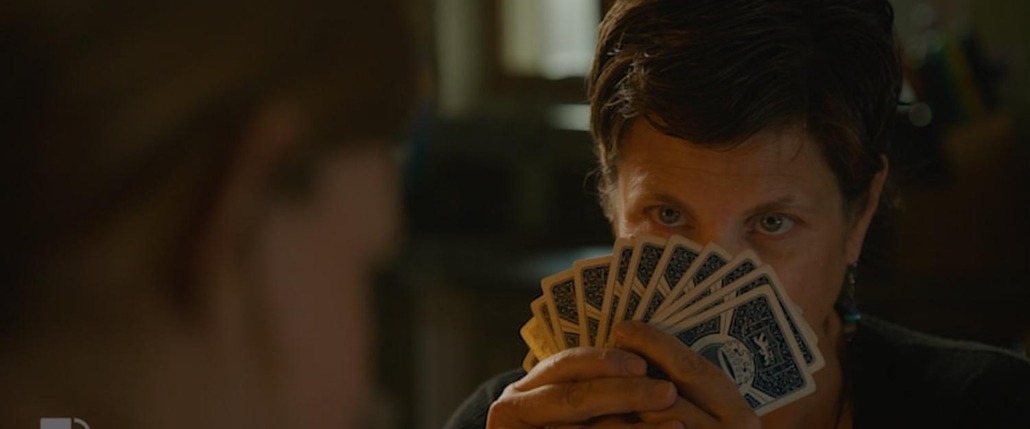 emma hides behind her cards